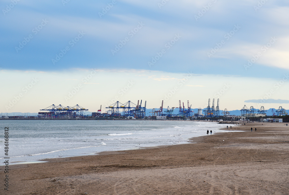 Fototapeta premium Coastline of Patacona beach overlooking Cabanyal beach and Malvarossa and seaport of Valencia. Empty beach and no peaple in spain during a pandemic. Sea with storm waves in winter season at resort..