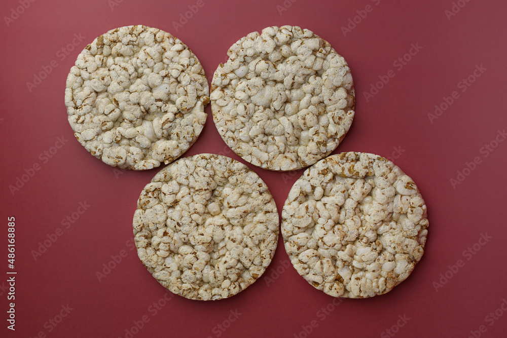 Rice buckwheat crispbread on an isolated background of Bordeaux color (Red-burgundy) top view Rice buckwheat crispbread on an isolated background of Bordeaux color (Red-burgundy) top view