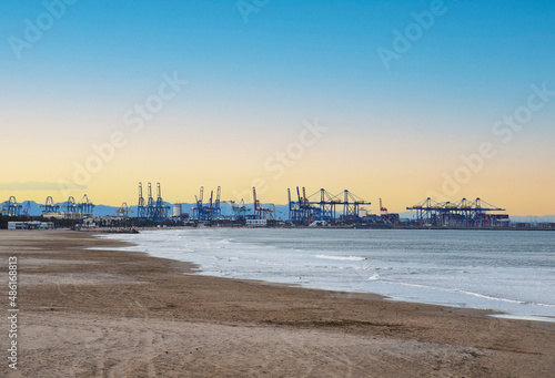 Waves in sea at coas on sunset. Coastline of beach overlooking seaport of Valencia. Empty beach at sea and no peaple in spain during a pandemic. Sea with storm waves in winter season at resort. . photo