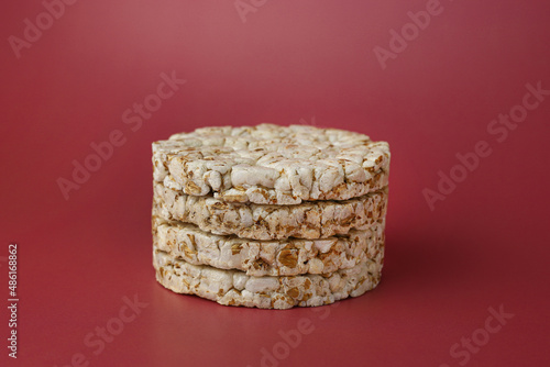 Rice buckwheat crispbread on an isolated background of Bordeaux color (Red-burgundy) close-up in the center