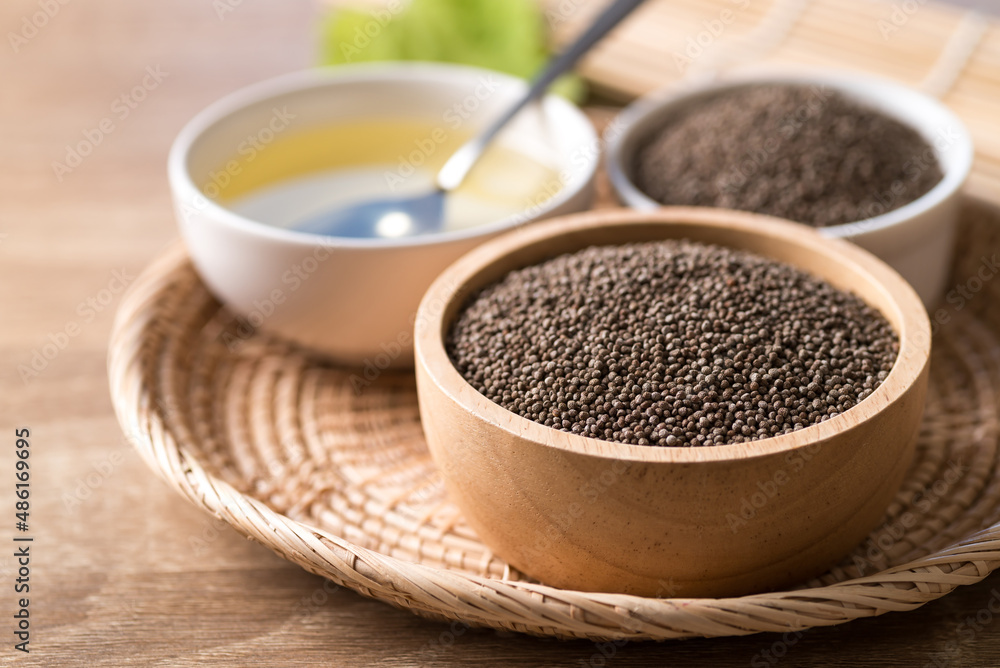 Perilla seeds and oil in bowl on wooden table, Healthy herbal seed ingredients in Asian food Perilla seeds and oil in bowl on wooden table, Healthy herbal seed ingredients in Asian food