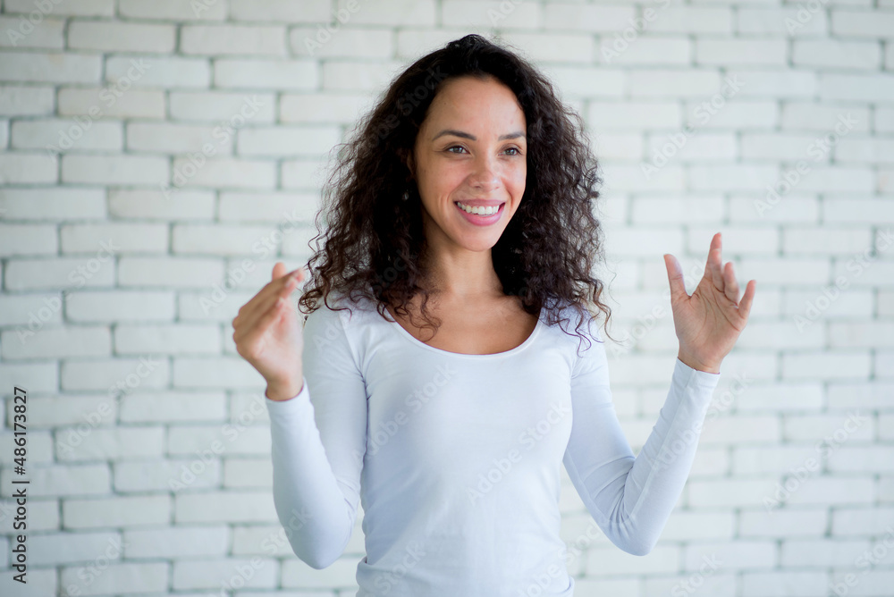 Amazed excited young woman afro hairstyle raising hands in surprise looking at camera with big eyes, shocked by sudden victory.studio shot isolated on white background Amazed excited young woman afro hairstyle raising hands in surprise looking at camera with big eyes, shocked by sudden victory.studio shot isolated on white background