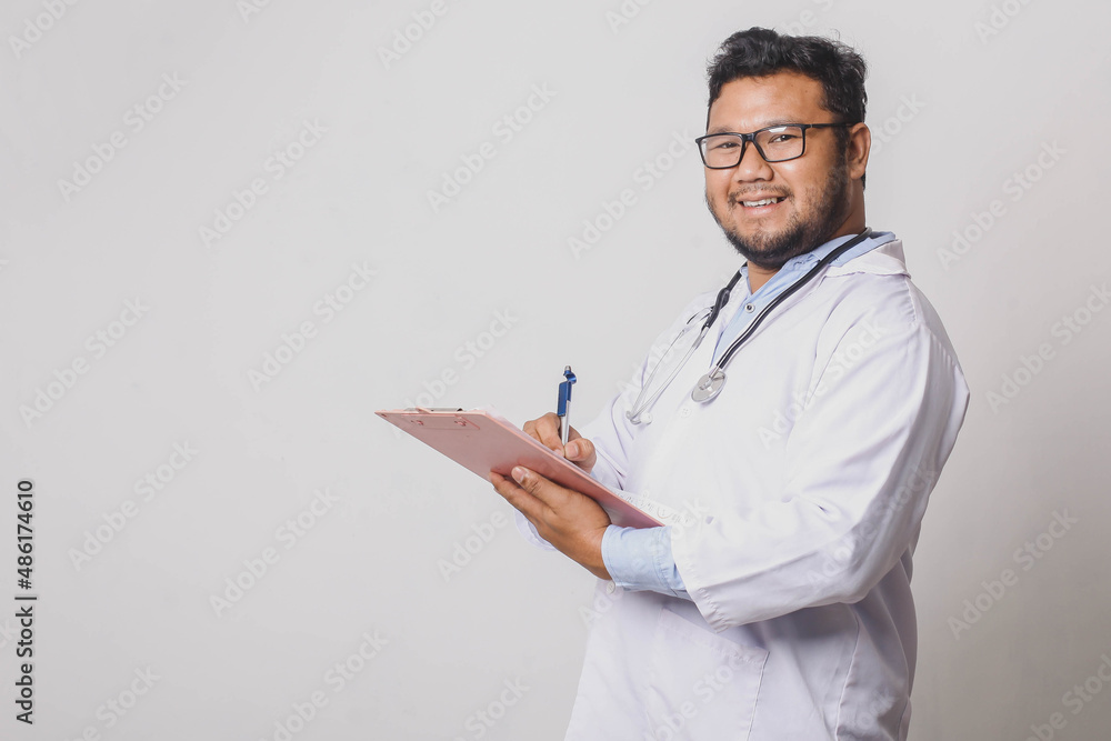Cheerful male doctor taking medical notes isolated on white background with copy space Cheerful male doctor taking medical notes isolated on white background with copy space