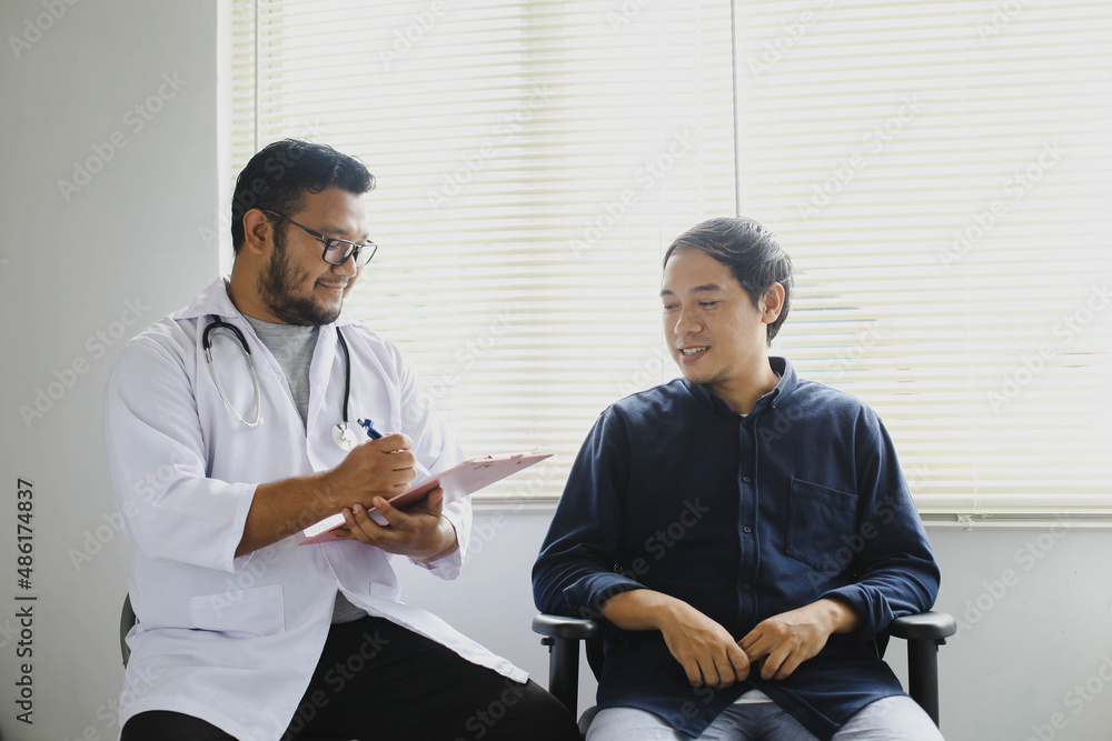 Cheerful doctor and patient while taking patient's medical record Cheerful doctor and patient while taking patient's medical record