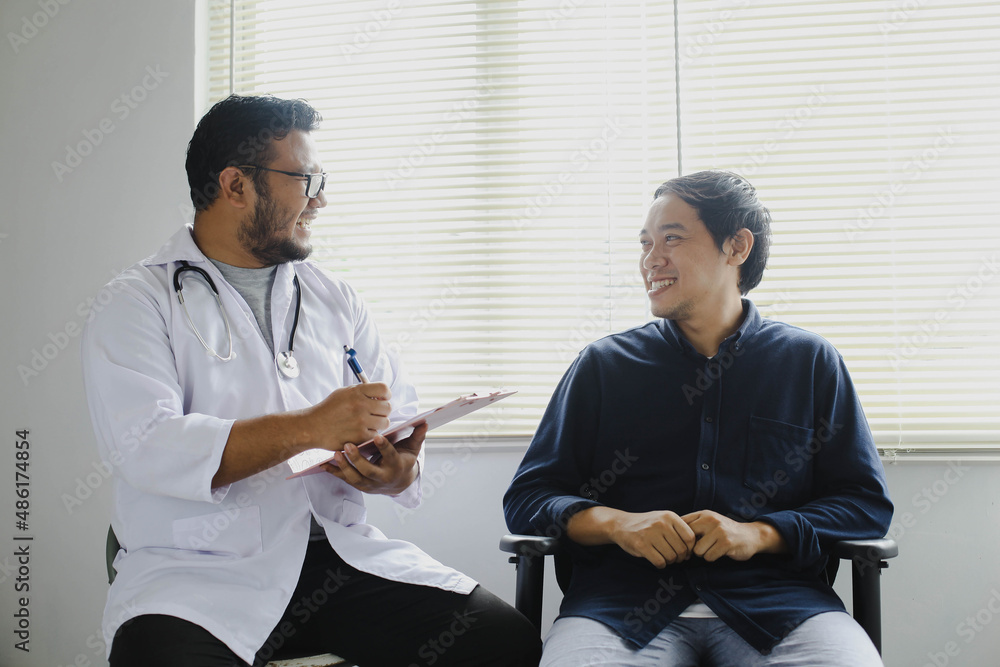 Obraz premium Cheerful doctor and patient while taking patient's medical record