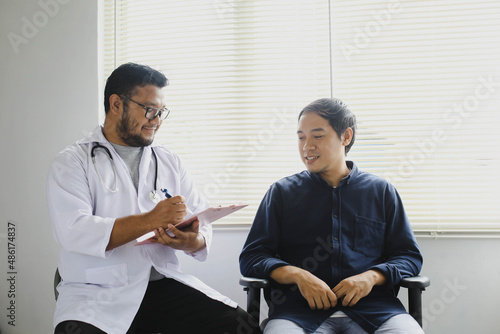 Cheerful doctor and patient while taking patient's medical record
