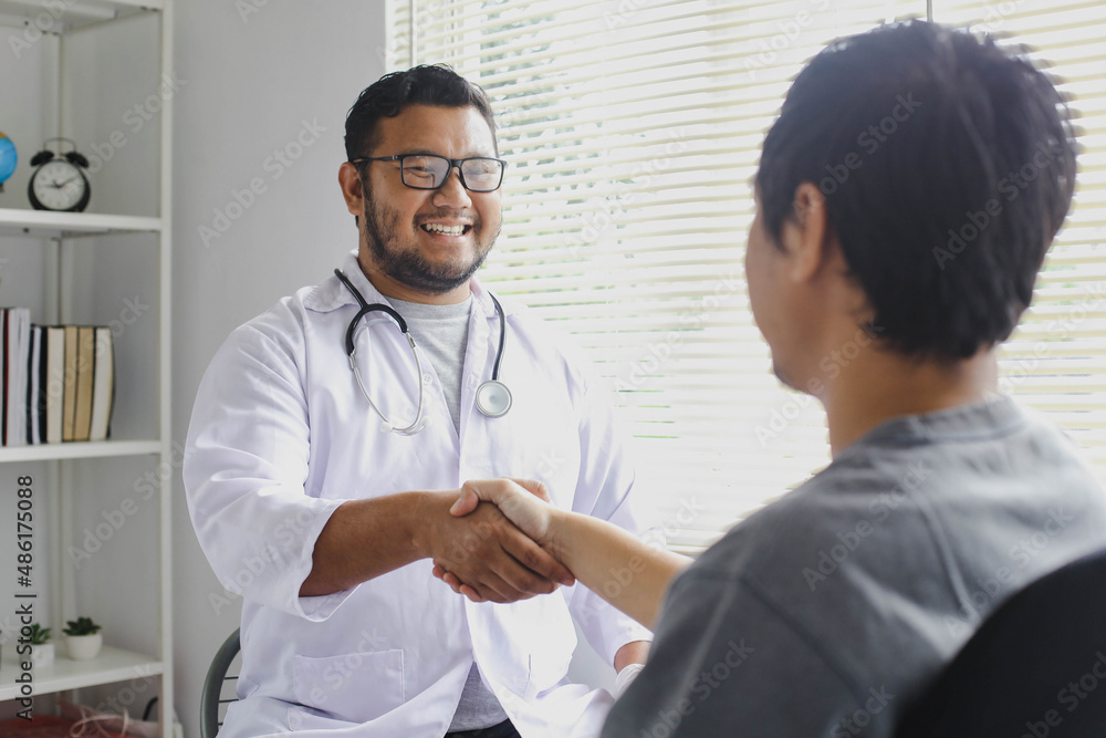 Happy smiling doctor greets his patient by shaking hands Happy smiling doctor greets his patient by shaking hands