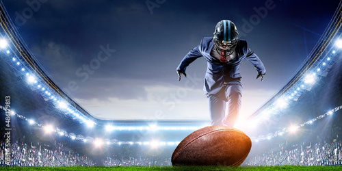 Businessman acting as american football players . Mixed media © Sergey Nivens