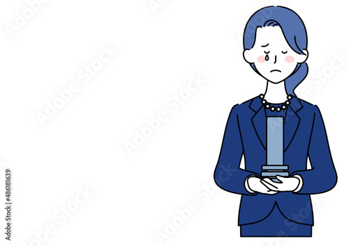 位牌を持ち涙する女性