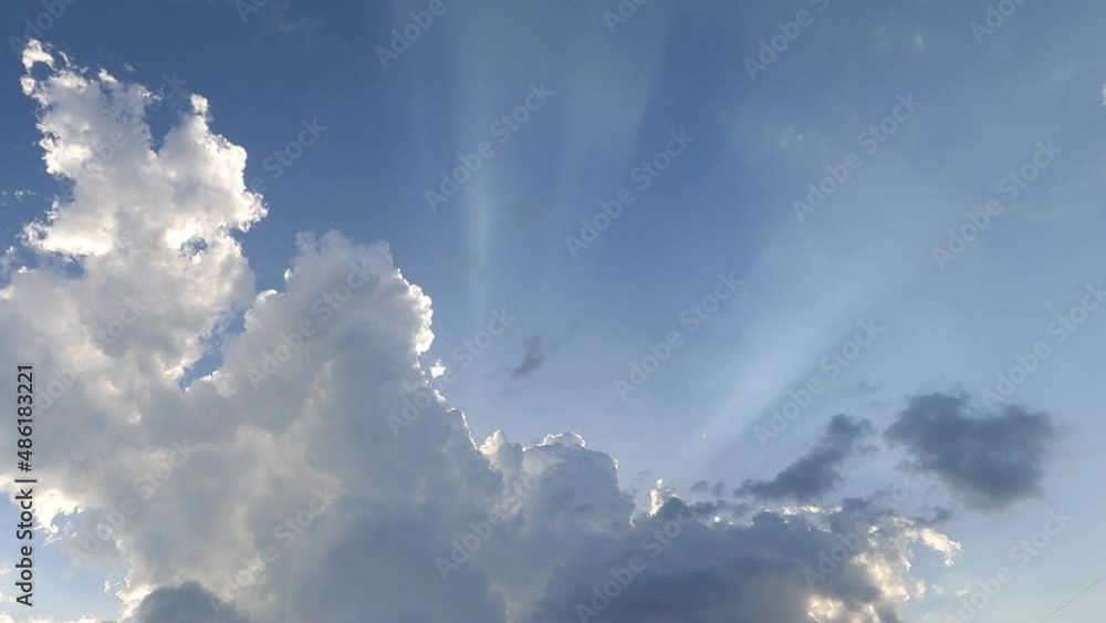 Dramatic rain clouds n sun light ray or sunbeam on blue sky