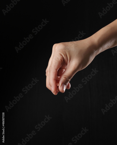 Hand holding pink salt on black background