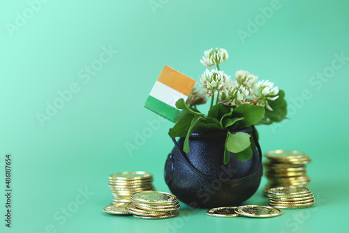  Saint Patrick holiday. Ireland flag , black bowler hat with gold coins, bunch of clovers on a green background. Patrick 's Day background photo