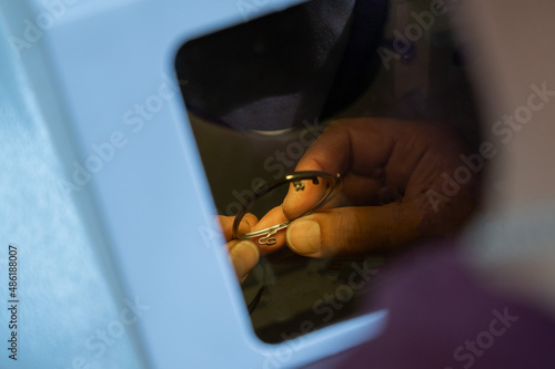 The technician solders the metal frame of the glasses. © Михаил Решетников