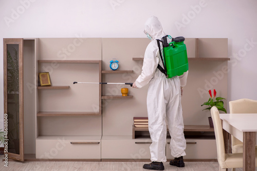 Φωτογραφία Young male contractor doing pest control at home
