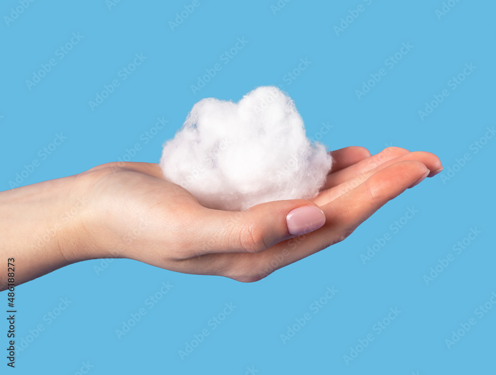 Hand holding cotton cloud at blue sky background. Dreaming or weather concept in surrealism style. High quality photo Hand holding cotton cloud at blue sky background. Dreaming or weather concept in surrealism style. High quality photo