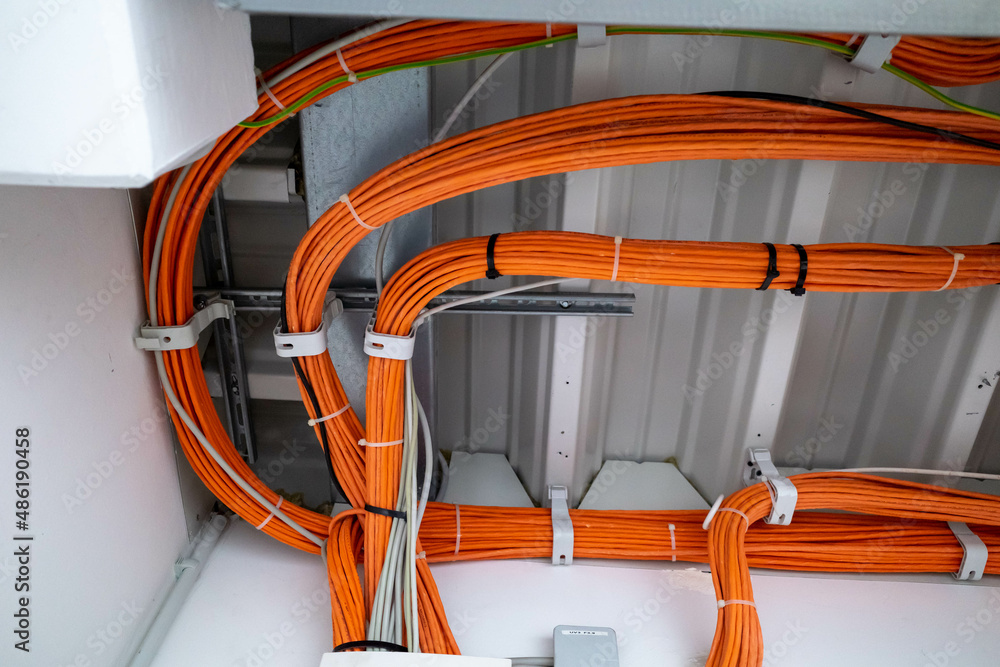orange network cables run bundled under the ceiling