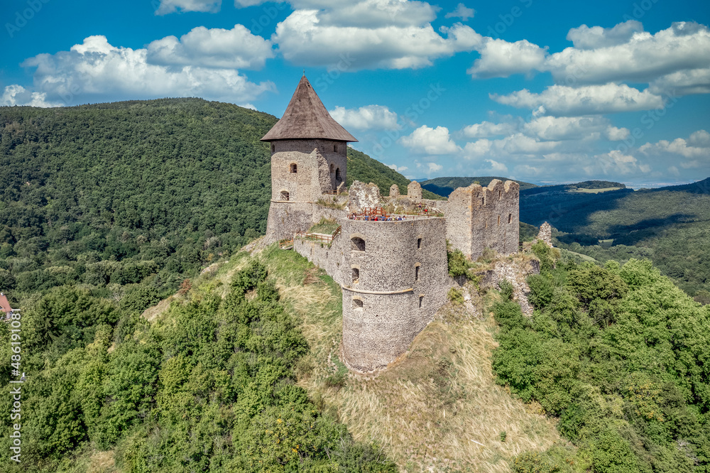 Aerial view of Somosko medieval castle between Slovakia and Hungary on a hilltop with triangle shape and three round towers, one cowered with a roof
