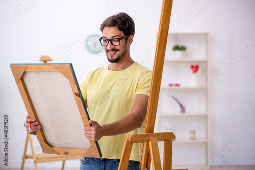 Young man enjoying painting at home