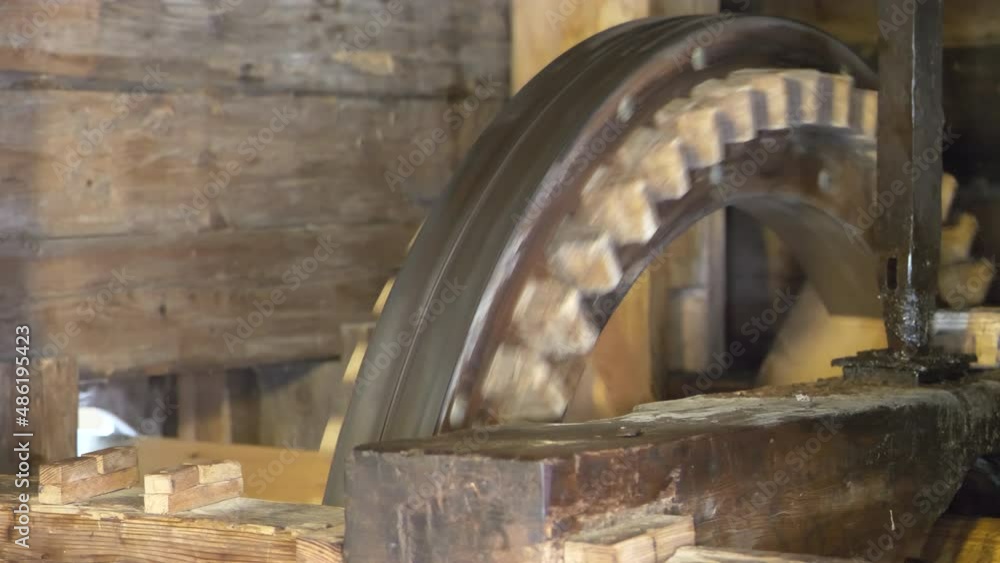 Close up shot of rotating cogwheels of old wooden water mill in nature Close up shot of rotating cogwheels of old wooden water mill in nature