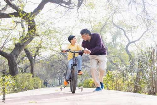 Father teaching son riding bicycle at park