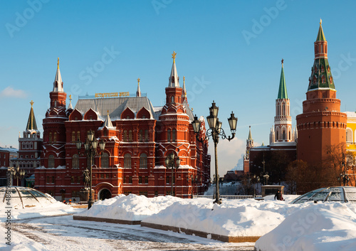 Scenic view of snow covered Manezhnaya Square overlooking building of State Historical Museum and corner Arsenal Tower of Moscow Kremlin, Russia..