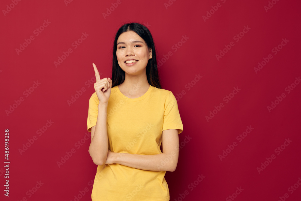 Portrait Asian beautiful young woman in a yellow t-shirt gesturing with his hands fun isolated background unaltered Portrait Asian beautiful young woman in a yellow t-shirt gesturing with his hands fun isolated background unaltered