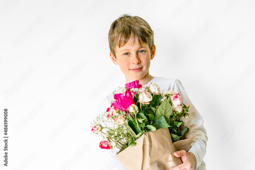 Portrait of an eight-year-old Caucasian boy with a bouquet of flowers in his hands with a gaze. Greeting card mockup with copy space Portrait of an eight-year-old Caucasian boy with a bouquet of flowers in his hands with a gaze. Greeting card mockup with copy space