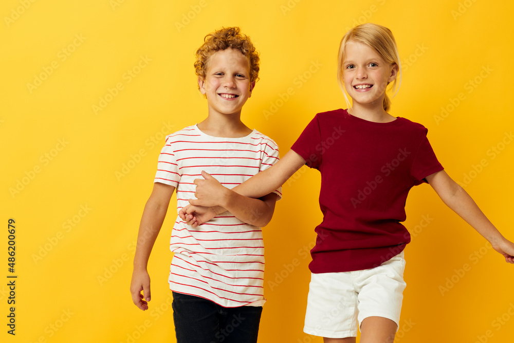 Small children casual wear games fun together yellow background Small children casual wear games fun together yellow background