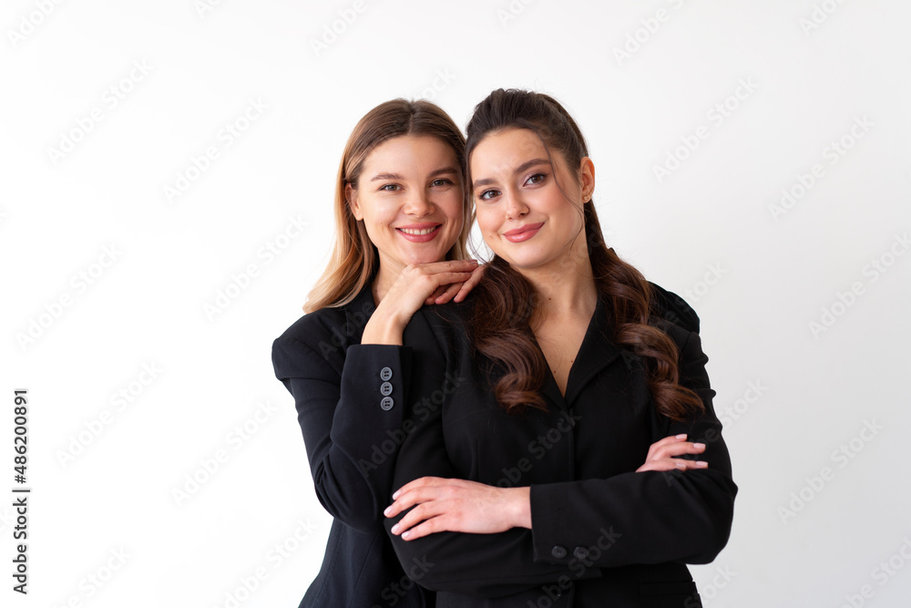 Concept of partnership in business. Two Young businesswoman dressed black formal suit standing studio isolated white background. Concept of partnership in business. Two Young businesswoman dressed black formal suit standing studio isolated white background.