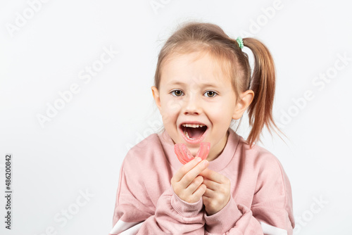 Adorable little girl puts myofunctional trainer in the mouth.