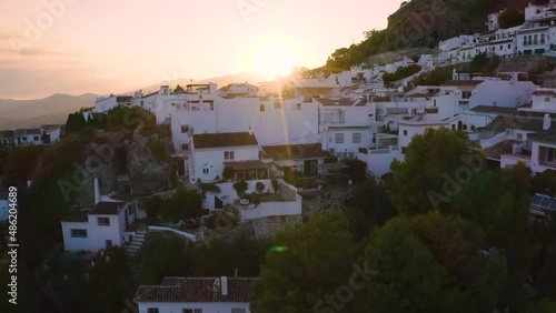 Rooftops of white houses in town Mijas in Spain at sunset, drone shot.