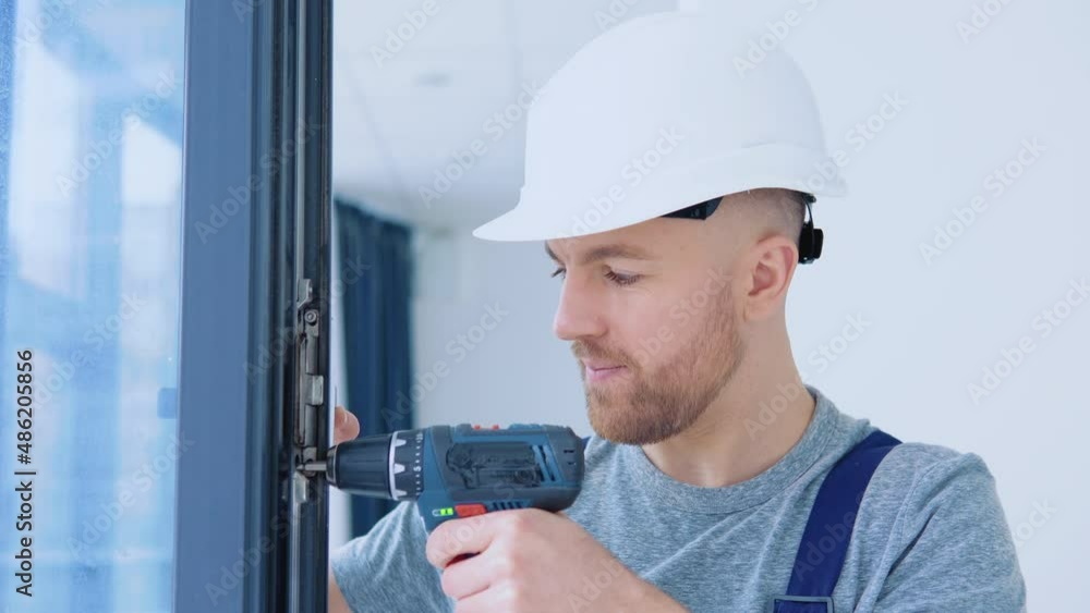 Master in a helmet and a screwdriver installs windows Master in a helmet and a screwdriver installs windows