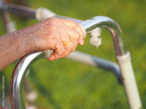 Closeup of a senior woman hand holding on to the walker. Elderly and healthcare concept.