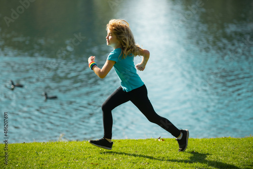 Child boy jogging in park outdoor. Sporty kid running in nature. Active healthy child boy runner jogging outdoor.
