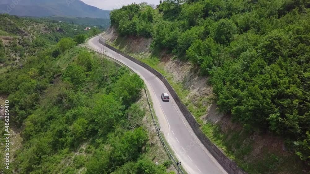 Van driving through the winding roads of Valbona Kukes in Albania, Eastern Europe. Aerial follow shot Van driving through the winding roads of Valbona Kukes in Albania, Eastern Europe. Aerial follow shot