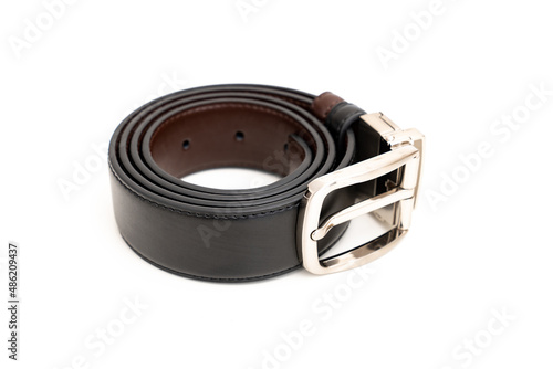 Double-sided black and brown leather belt with an unbuttoned buckle on a white background.