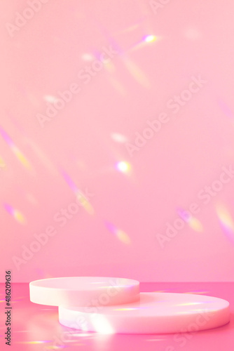 Abstract minimal scene - empty stage, cylinder podiums on soft pink background with rainbow crystal light refraction sparkles. Pedestal for cosmetic product and packaging mockups display presentation