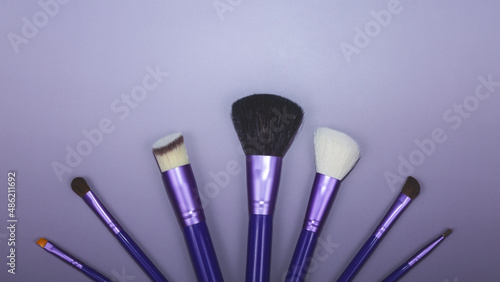 beauty makeup product layout. Fashion woman makeup brushes on violet background. Stylish design background. Creative fashion concept. Cosmetics makeup brushes collection, top view, banner