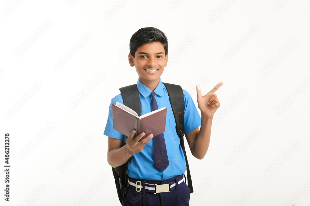 Indian school boy in uniform and reading diary on white background. Indian school boy in uniform and reading diary on white background.