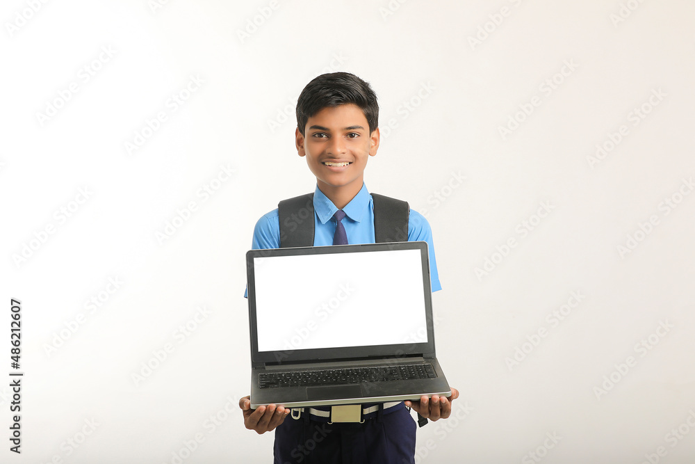 Indian school boy showing laptop screen on white background. Indian school boy showing laptop screen on white background.