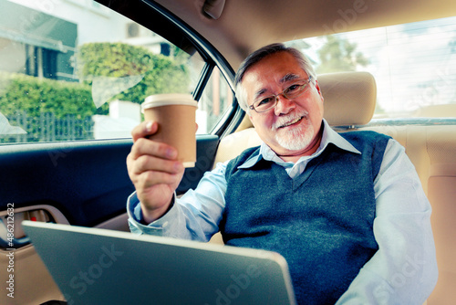 Adult senior executive luxury business old man sitting with laptop computer at back of car seat ,Technology transport lifestyles concept.