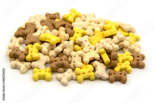 Dog treats. Bone shaped cookies for dogs. Multi colored bones of cookies isolated on a white background. Closeup