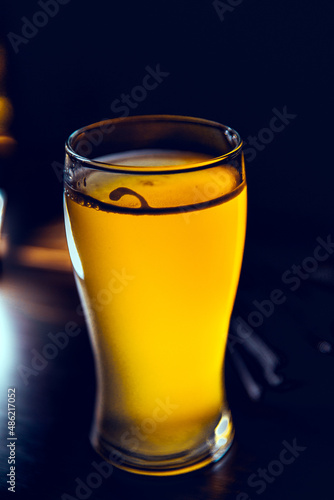 Glass glass of beer and breaded onion rings on a bar counter
