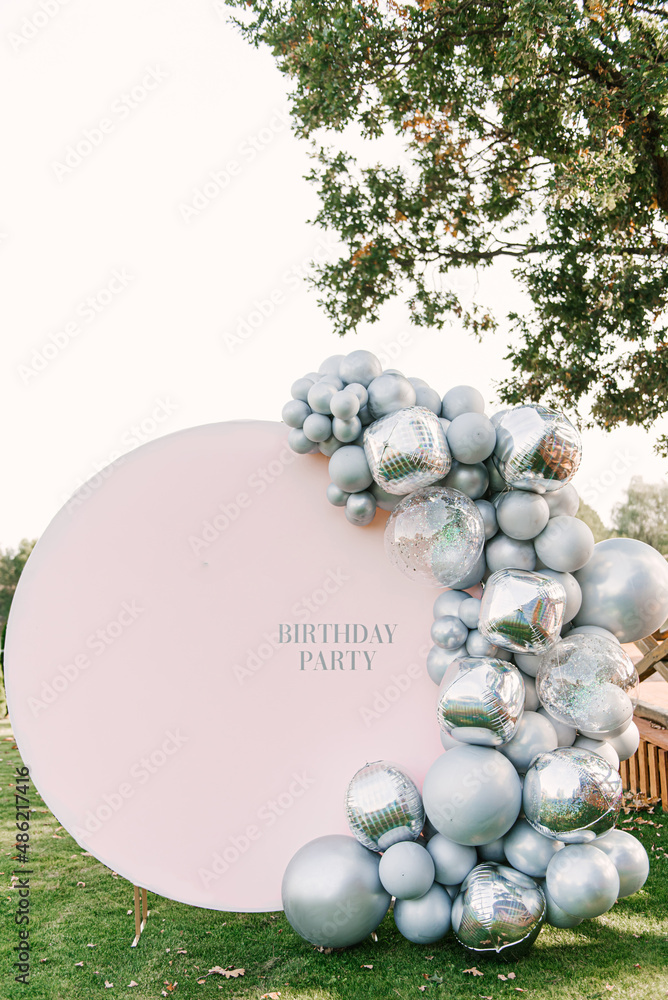 Round pink photo zone made of silver balloons with space to copy your text. Party decorated with balloons