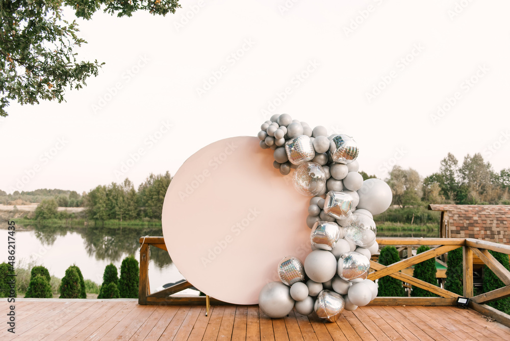 Round pink photo zone made of silver balloons with space to copy your text. Party decorated with balloons
