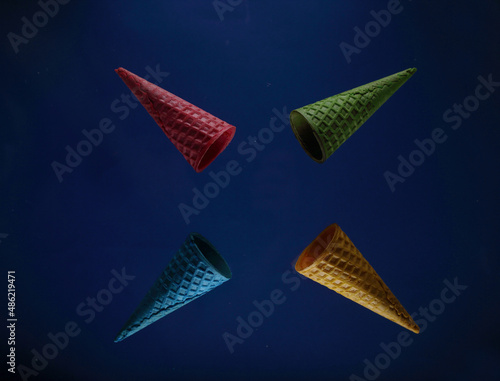 four waffle cones of different colours isolated against blue background