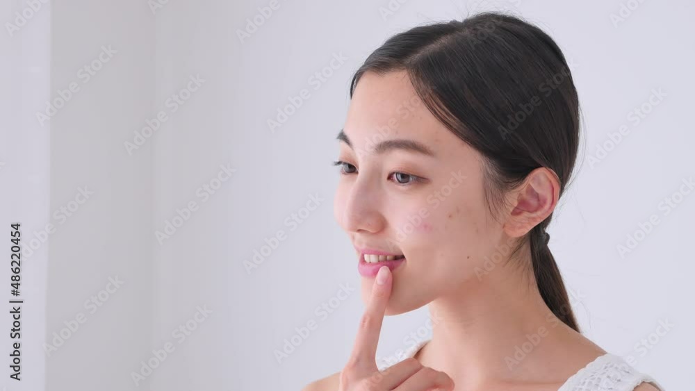 口元を指差す女性