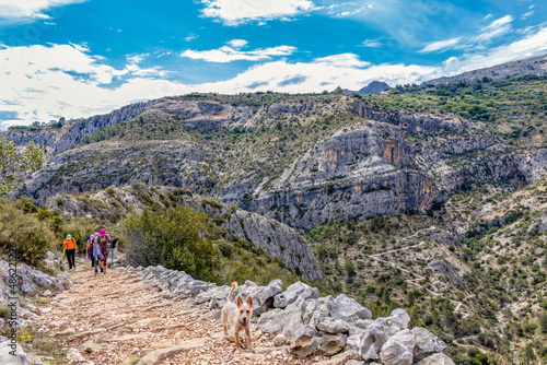 Group of hikers in the Route of Six Thousand Steps, at Barranc de l’Infern. The Hell’s Ravine in Vall de Laguar, Alicante, Spain photo