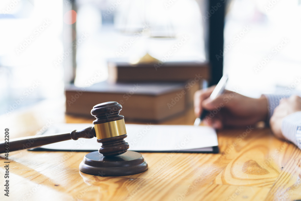 Business and lawyers discussing contract papers with brass scale on desk in office. Law, legal services, advice, justice and law concept. Business and lawyers discussing contract papers with brass scale on desk in office. Law, legal services, advice, justice and law concept.