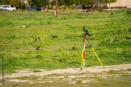 Geodetic measuring equipment stands on the field. Topographic survey of the area.
